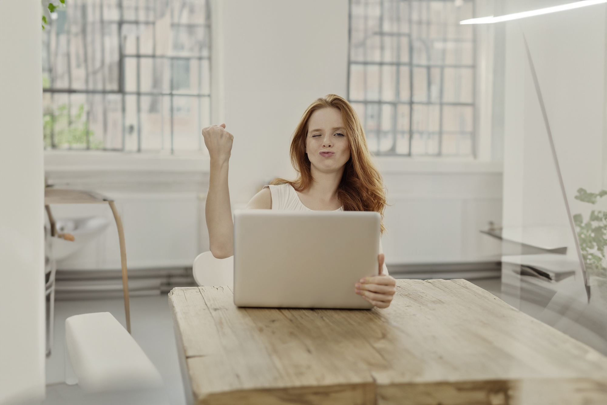 frau am laptop ballt zufrieden die faust